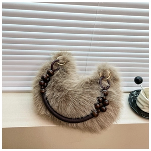 Detail of camel plush faux fur handbag with stylish beaded handle and gold metal rings