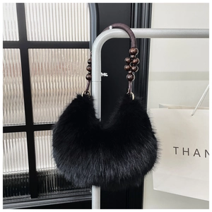 Detail of black faux fur crescent handbag with unique dark brown wooden bead handle