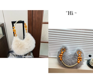 Detail of plush handbag with bohemian wooden bead handle in cream and dark gray