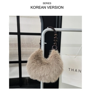 Detail of camel plush handbag featuring a beaded brown handle and soft faux fur texture