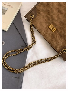 Dettaglio della borsa trapuntata marrone con texture scamosciata e chiusura girevole oro