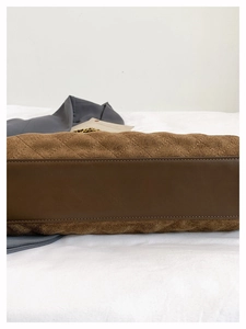 Dettaglio della borsa trapuntata marrone con cuciture precise e trama della pelle