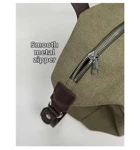 Détail du zip en métal fluide et de la texture de la toile de sac vert olive