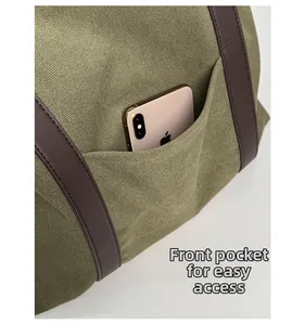 Détail du sac cabas en toile vert armée montrant la poche avant pour un smartphone