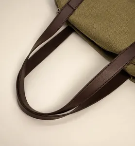 Détail du sac cabas en toile avec poignées en cuir marron et coutures de qualité