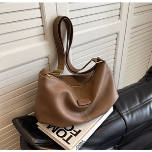 Detailansicht braune Tasche mit Litschi-Narbung Leder, Mode-Logo und goldener Schnalle