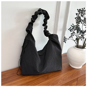 Detail view of black grid pattern shoulder bag with a unique scrunchie strap design