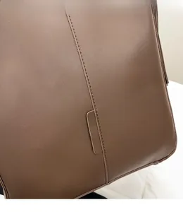 Detailed close-up of brown leather tote featuring precise double-line stitching craft