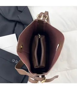 Internal view of brown leather tote with inner pouch and gold magnetic snap closure