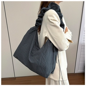 Detail of checkered canvas shoulder bag with pleated strap and large capacity