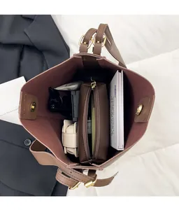 Macro view of large brown faux leather tote bag interior with magnetic gold clasp