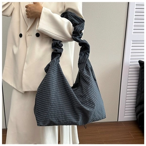 Detailed view of checkered canvas tote bag with ruched handles and spacious interior