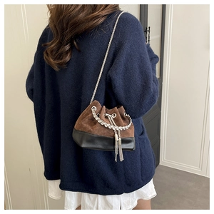 Détail du sac seau bicolore avec chaîne argentée et pompon en strass chic