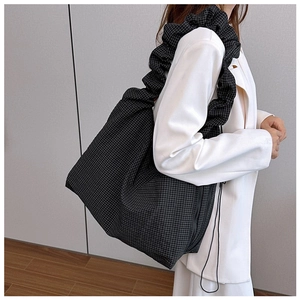 Canvas tote bag with black and white check pattern and ruffled strap detail on shoulder