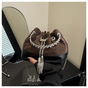 Détail du sac seau en daim avec poignée en cristal et bandoulière chaîne à glands