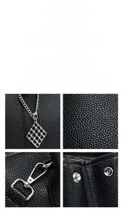 Close-up of black lychee grain leather texture and silver metal hardware on a shoulder bag
