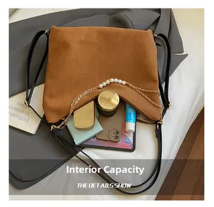 Brown suede shoulder bag interior showing large capacity with tablet and cosmetics