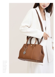 Detail of brown litchi pattern leather tote with wide strap and protective metal feet