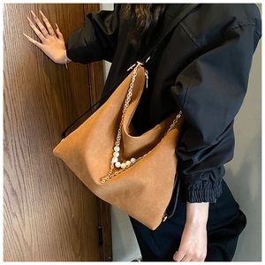 Close-up of brown suede hobo bag featuring pearl and metal chain decorative details