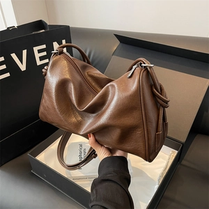 Close-up of brown vintage Boston bag with pleated leather texture on a gift box