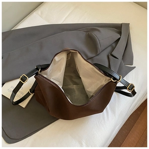 Detailed view of the brown shoulder bag interior with spacious compartment and zipper