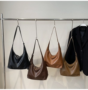Hanging display of four leather hobo bags in black, brown, caramel, and khaki colors