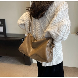 Detail of dark brown vintage Boston bag showing side knot design and soft leather texture