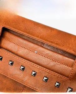 Detail einer Vintage-Ledertasche in Braun mit quadratischen Nieten und Tragegriff