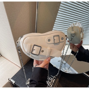 Détails du sac blanc en forme de cœur avec rivets argentés et bandoulière chaîne