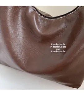 Detailed close-up of dark brown leather texture and soft fabric on a large crossbody bag