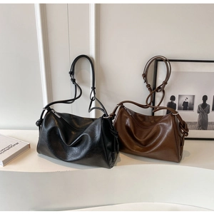 Detail of vintage Boston bags in black and brown soft leather with elegant knotted straps