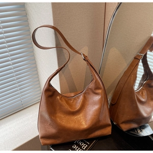 Detail of vintage brown leather hobo bag with silver adjustable buckle and zipper closure