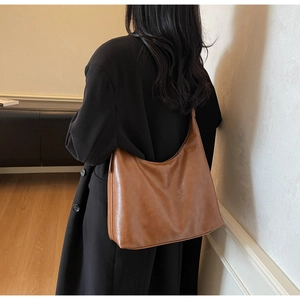 Close-up of vintage brown leather tote bag showing textured finish and large capacity