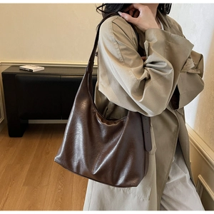 Detail view of large dark brown hobo shoulder bag in premium textured leather style