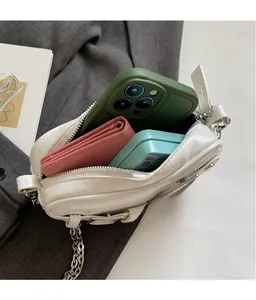 Vue intérieure du mini sac blanc montrant l'espace pour téléphone et portefeuille