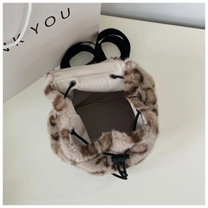 Macro view of leopard print plush bucket bag with drawstring closure and interior lining