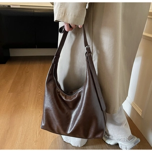 Detailed view of dark brown faux leather hobo bag with adjustable shoulder strap and zipper