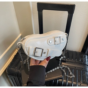 Détail du sac bandoulière blanc en forme de cœur avec boucles argentées et chaîne