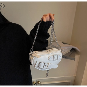 Détail d'un mini sac cœur blanc avec des boucles argentées et une bandoulière en chaîne fine