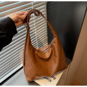 Detail of brown litchi pattern PU leather texture on hobo shoulder bag with zipper