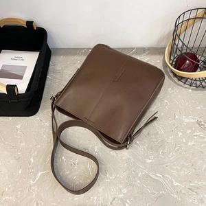 Deep brown minimalist tote bag with smooth finish on marble surface in a 45-degree angle view