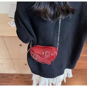 Vue détaillée du sac à main rouge en forme de cœur avec chaîne argentée et boucles métal