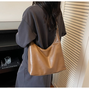 Detailed back view of a retro brown faux leather hobo shoulder bag with adjustable strap