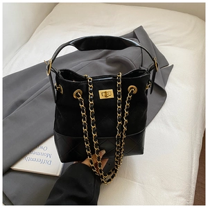Detail of black suede and quilted leather bucket bag with gold chain and twist lock