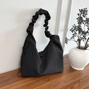 Plaid canvas shoulder bag with pleated handle and large capacity in a minimalist setting
