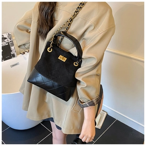 Detail of black quilted shoulder bag with gold turn-lock and leather chain strap