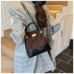 Detail showing mixed texture bucket bag with brown suede and black quilted leather