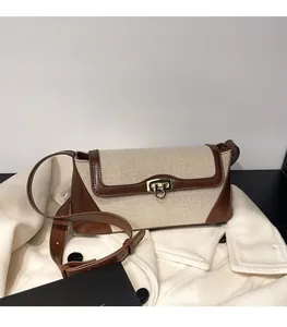 Close-up of contrast leather and canvas stitching with golden metal buckle on retro handbag