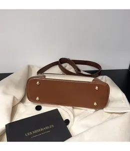 Close-up of bag bottom with protective gold rivets and contrast leather stitching