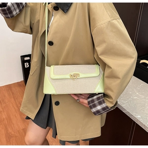Detail of green leather and tweed patchwork crossbody bag with golden round clasp on model